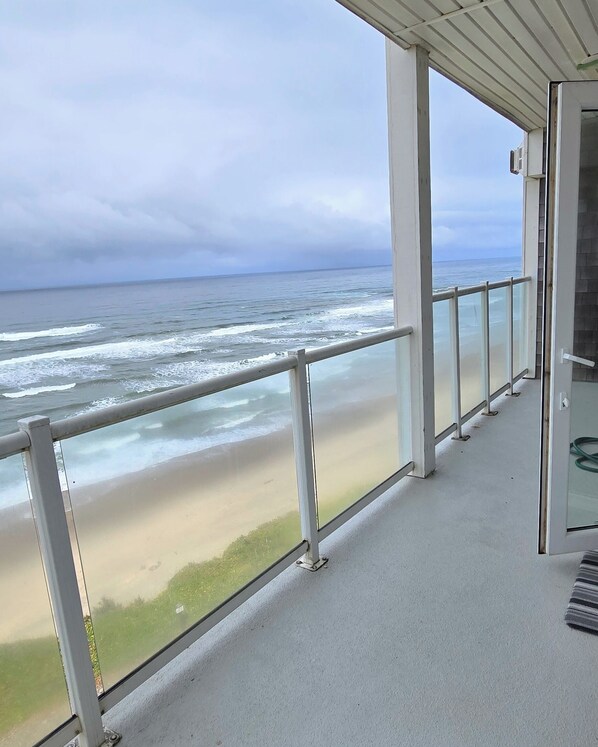 A balcony with a view of the beach and ocean.