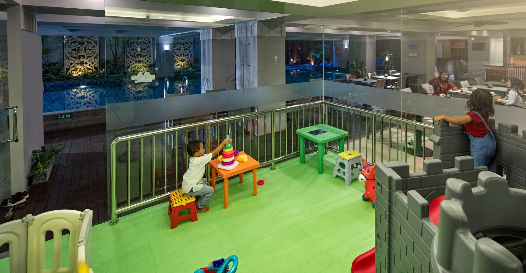 A children's play area with a pool, tables, and chairs.