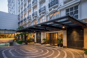 A hotel entrance with a covered walkway, large windows, and potted plants. - eL Hotel Yogyakarta Malioboro (Yogyakarta)