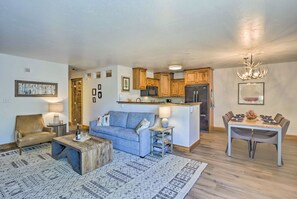 Relax in this inviting living space with a sofa, coffee table, and dining area, perfect for family meals.