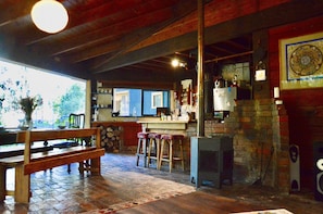 Cozy space with a brick fireplace, wooden bench, and kitchen appliances.
