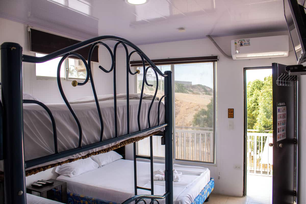 A bunk bed room with a window and an air conditioning unit.