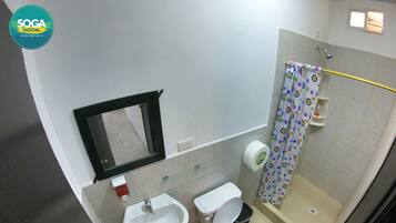 Un baño con lavamanos, inodoro y ducha.