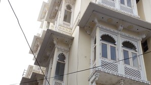 Un immeuble à plusieurs étages, doté de balcons richement décorés et de détails architecturaux traditionnels.