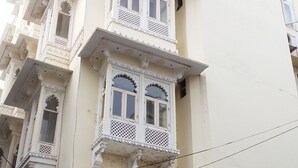 Un immeuble à plusieurs étages, doté de balcons décorés et d’une enseigne indiquant la présence d’un restaurant.