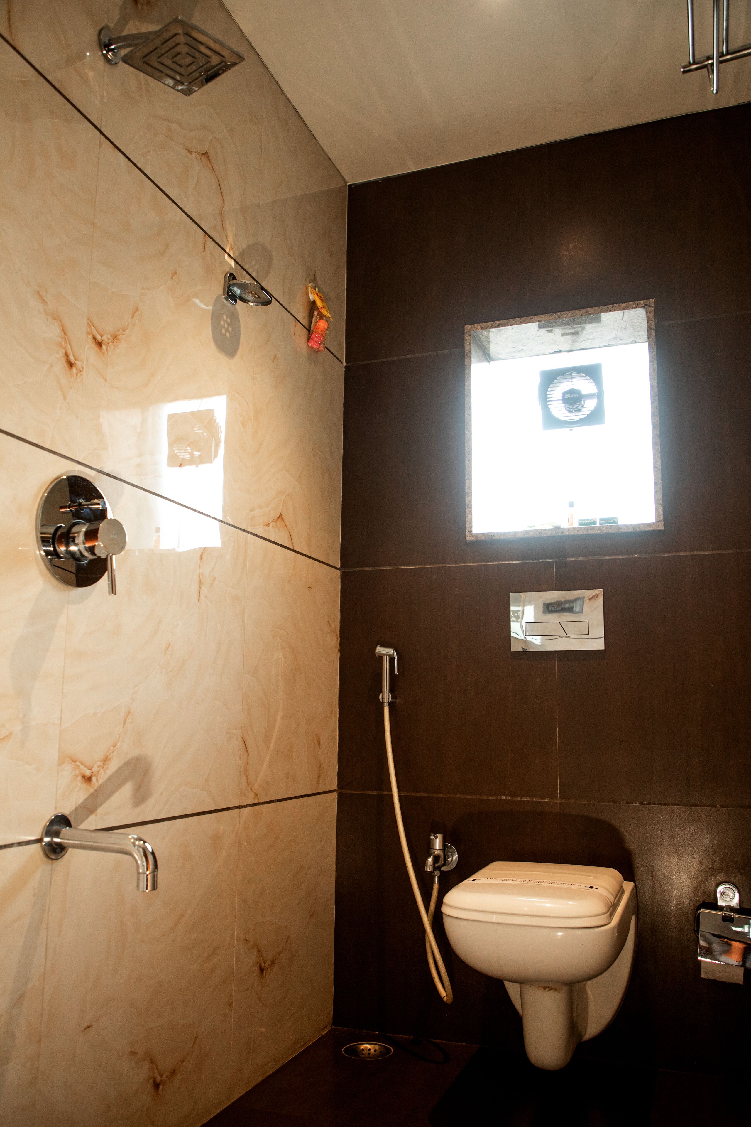 Un baño con inodoro, ducha y ventana.