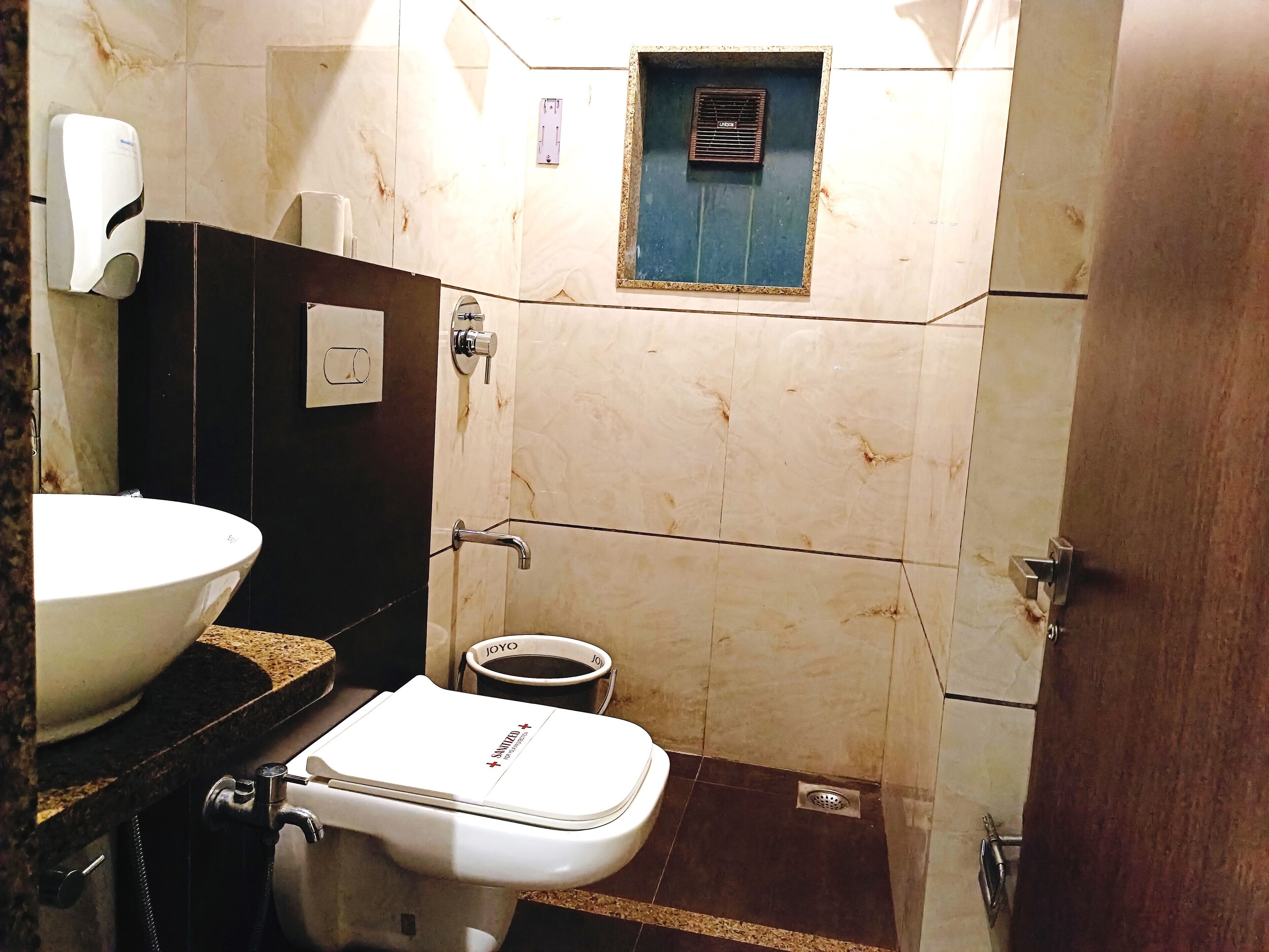 Un baño con un lavamanos blanco, un inodoro y una zona de ducha.