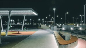 Un espace extérieur bien éclairé, avec un chemin menant à un espace de repos abrité.