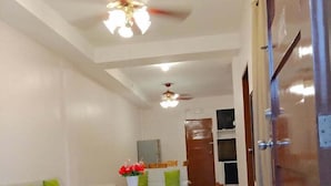 A spacious living area with a sofa set, a coffee table, and a ceiling fan. - Red Forest Guest House (Coron)
