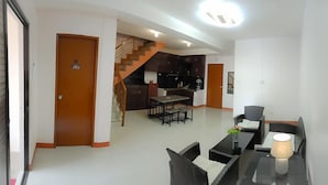 A modern apartment with a dining area, kitchen, and staircase. - Red Forest Guest House (Coron)