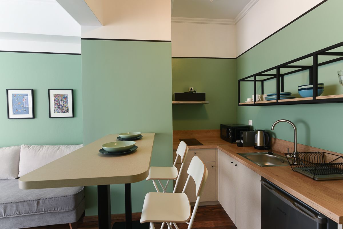 A compact kitchen with a dining area, a sofa, and a small dining table.