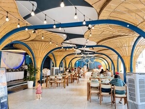 A spacious restaurant with high ceilings and a curved wooden ceiling design. Tables are arranged for dining, and there are people seated. - Nha VIET Nha Trang Hotel (Nha Trang)