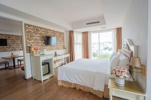 A hotel room with a bed, a desk, a television, and a view of the city. - Nha VIET Nha Trang Hotel (Nha Trang)