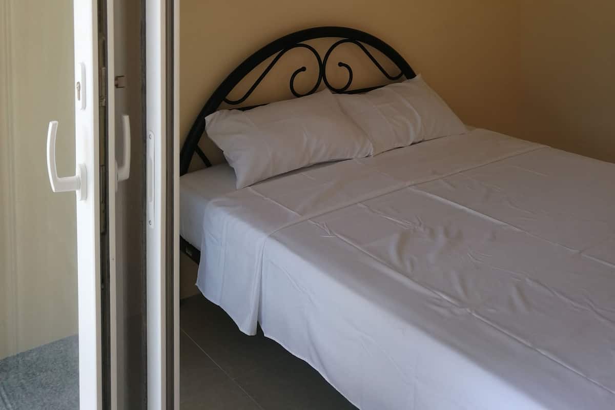 Un dormitorio con cama, aire acondicionado y una puerta.