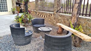 Outdoor seating with wicker chairs and a round table, surrounded by gravel and plants. - Hidaway Resort (San Antonio)