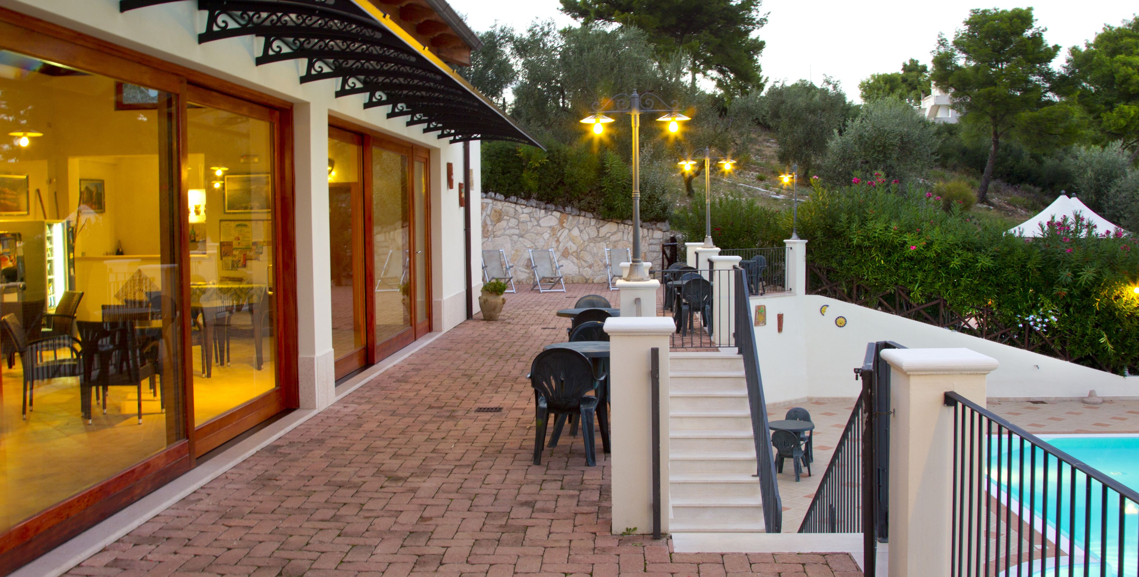 A patio area with outdoor seating, a pool, and a stone wall.