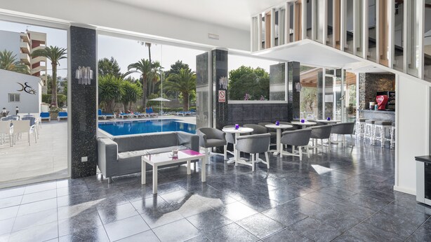 Un área de piscina interior moderna con bar y asientos.