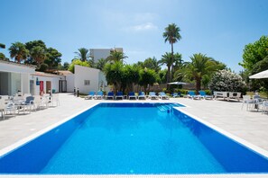 Una piscina al aire libre, tumbonas