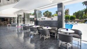 Un espacio interior moderno con asientos y vista a una piscina.