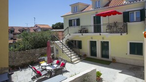 A two-story house with a balcony, outdoor seating, and a staircase. - Central Old Town Rooms (Split)