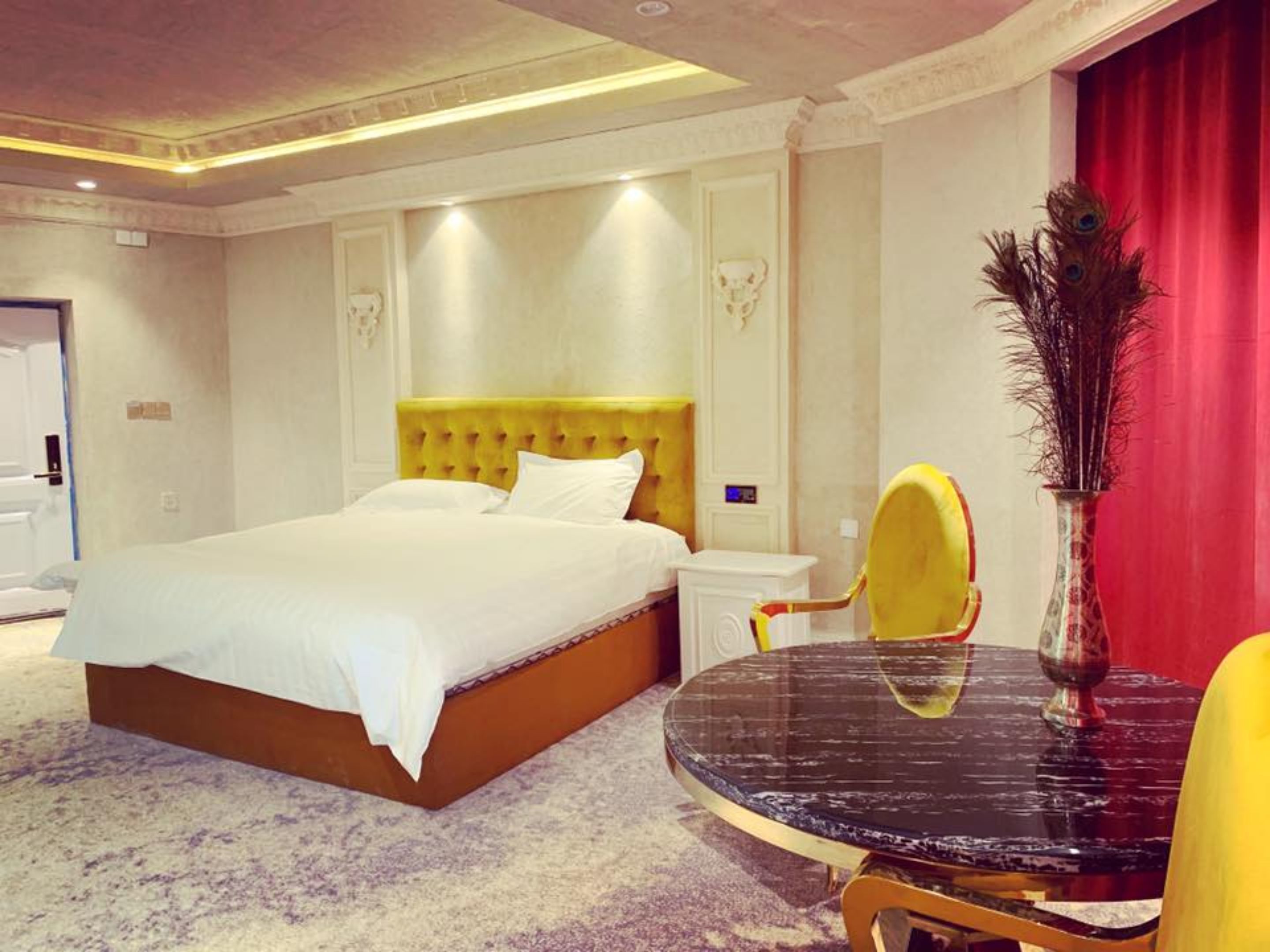 Una habitación de hotel con una cama grande, una mesa redonda y una silla.