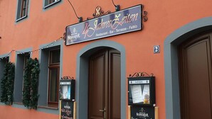 Un edificio con un letrero que dice "4 Jahre" y "Restaurante - Bar - Terraza - FeWo".