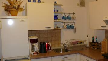 A kitchen with a Bosch refrigerator, a coffee maker, a toaster, and a sink.
