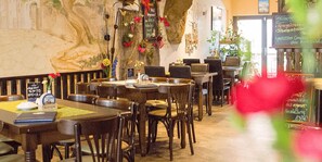 A restaurant with wooden tables and chairs, a chalkboard menu, and a mural on the wall. - 4 JahresZeiten (Meissen)