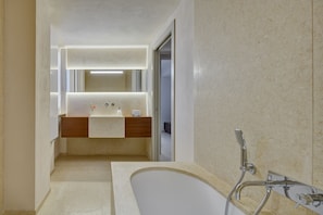 Une salle de bain moderne avec une baignoire sur pieds, un meuble-lavabo avec un miroir et une pomme de douche.