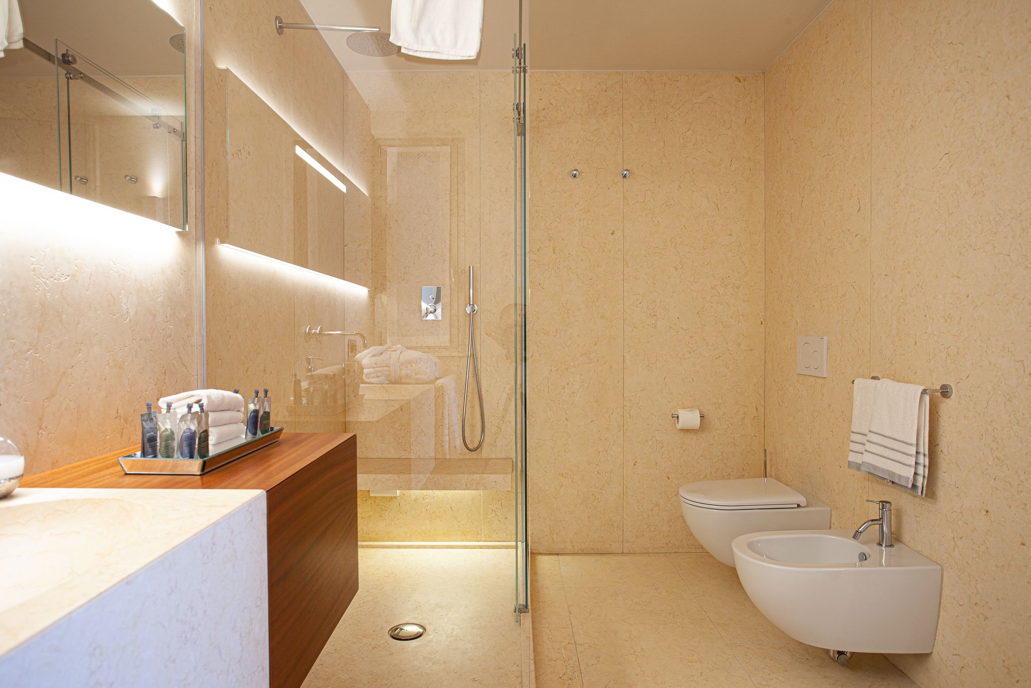 A modern bathroom with a glass-enclosed shower, a vanity with a mirror, and a sink.