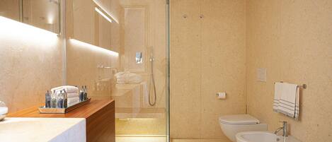 A modern bathroom with a glass-enclosed shower, a vanity with a mirror, and a sink.