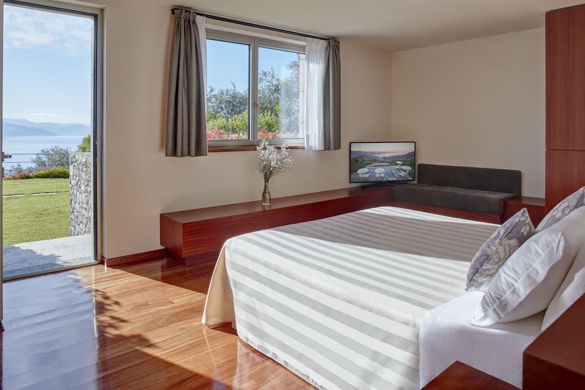 Un dormitorio moderno con una cama grande, un televisor y vistas al exterior.