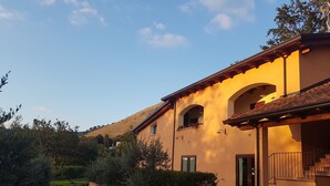 A building with a beige exterior, arched windows, and a tiled roof. - Agriturismo L'Ulivo (Padula)