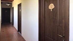 A hallway with wooden doors and a tiled floor. - Agriturismo L'Ulivo (Padula)