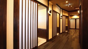 A hallway with sliding doors, a tiled floor, and a sign indicating a toilet. - Himakajima Ocean View Hotel Seikaiso (Minamichita)