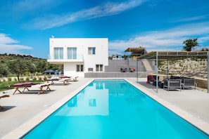 Piscine extérieure en saison, chaises longues