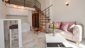 Eine moderne Wohnung mit Küche, Wohnbereich und einer Treppe zu einer oberen Etage.