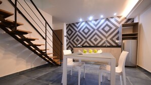 A modern kitchen with a dining table, chairs, and a staircase. - Brazilia Suites Hotel (Baabda)