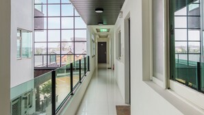 A corridor with large windows, a glass railing, and a clear view of the outside. - Kano Resort (Luodong)