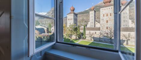 A view from a window overlooking a historic building with stone architecture and domed roofs.