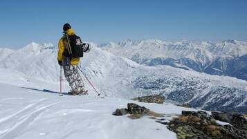 A person on a snowy mountain with a clear view of distant mountains.