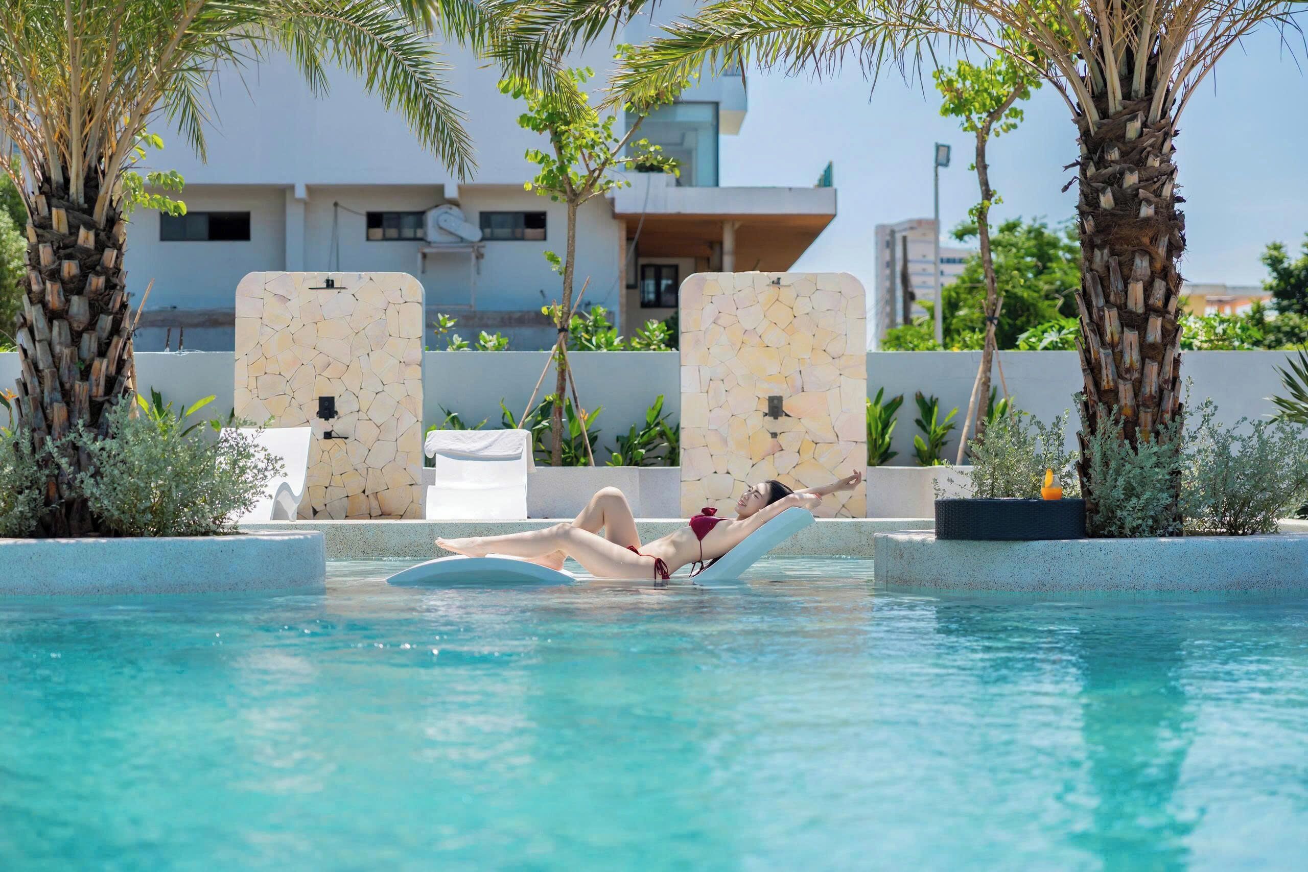 Una piscina al aire libre, sillones reclinables de piscina
