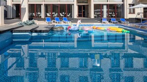 A swimming pool with lounge chairs and a decorative flamingo float. - Redling Hotel (Odesa)