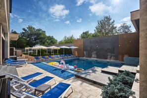 Piscine extérieure en saison, chaises longues