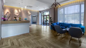 A modern hotel lobby with a reception desk, seating area, and large windows. - Redling Hotel (Odesa)
