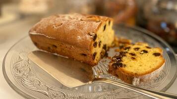 A loaf of fruitcake on a decorative glass plate.