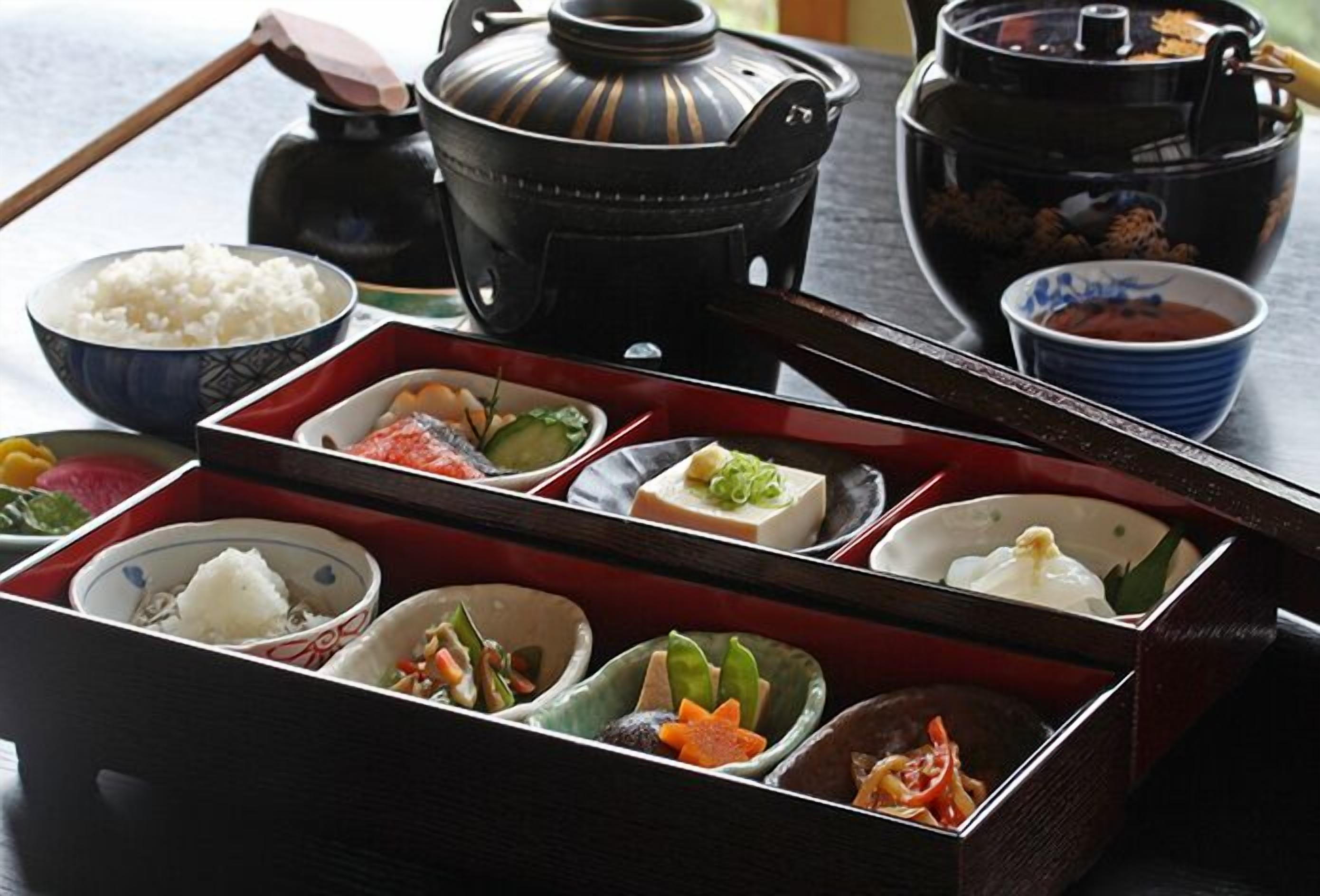 A traditional Japanese meal setup with various dishes and a tea pot.