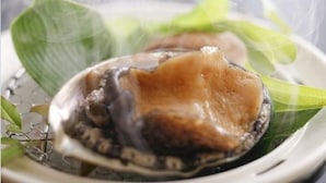 A plate with a clam, green leaves, and a decorative element. - Koujin no Yado Sanpou (Kami)