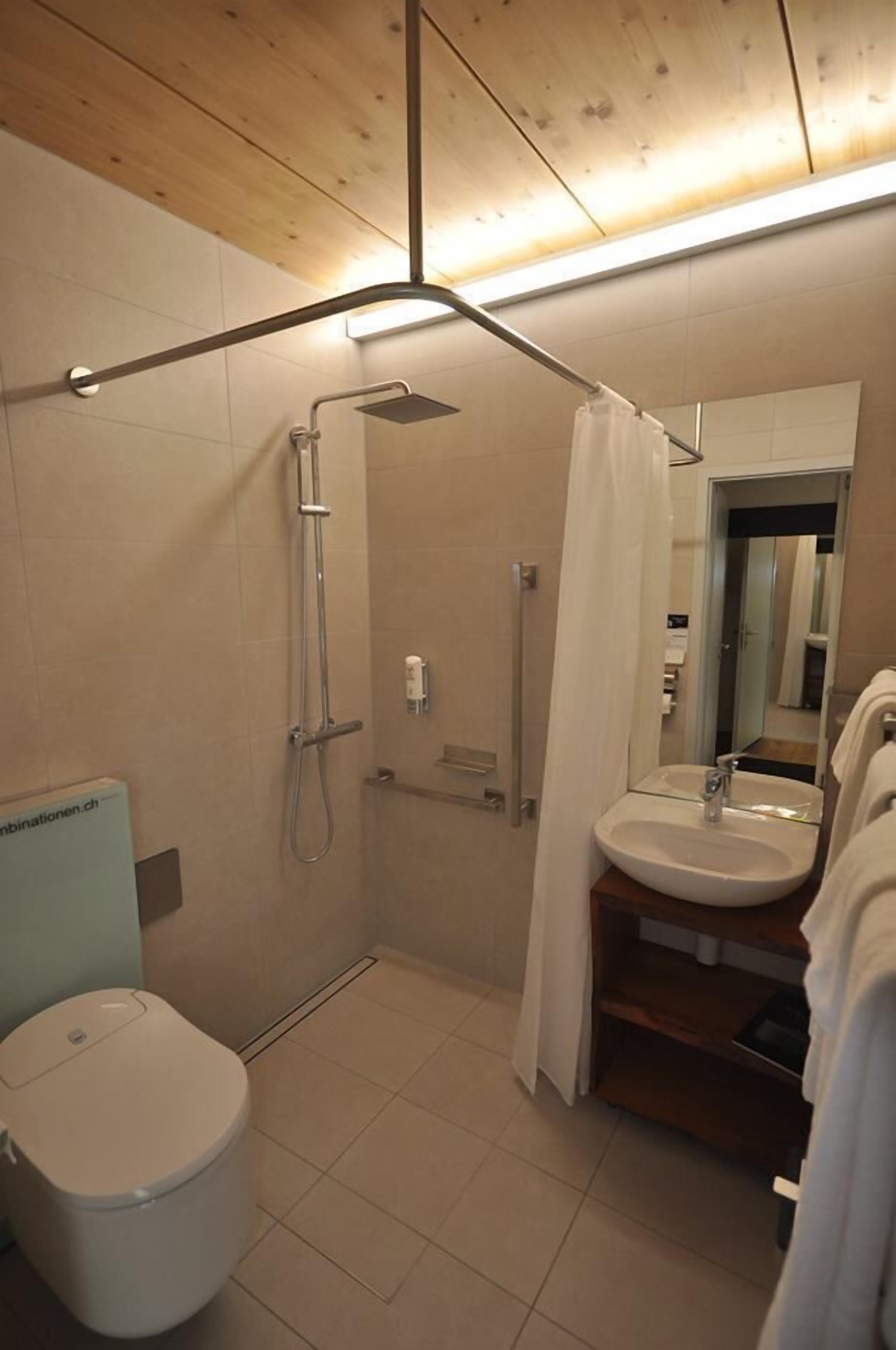 Une salle de bain moderne équipée d’une douche, de toilettes et d’un lavabo.