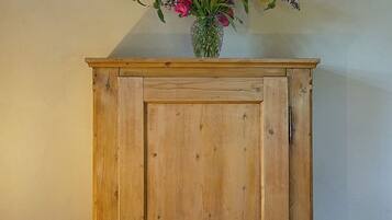 A wooden cabinet with a floral arrangement on top.